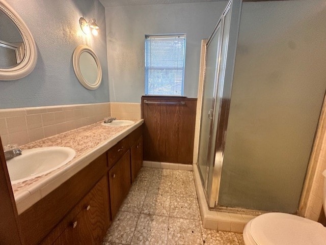 1215 Briar Ln, Wharton, TX 77488 - full bathroom featuring a stall shower, double vanity, tile patterned flooring, and a wainscoted wall