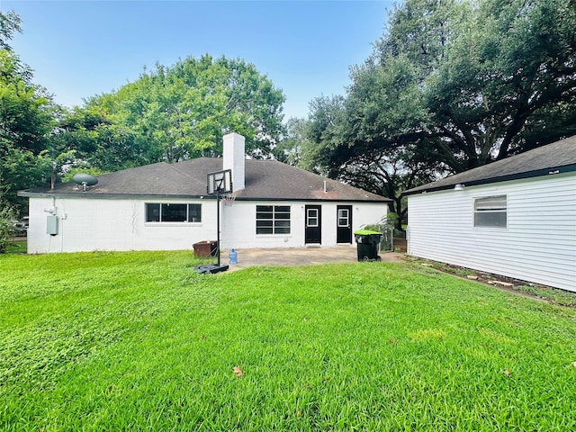 1215 Briar Ln, Wharton, TX 77488 - back of house with a patio, a chimney, and a lawn