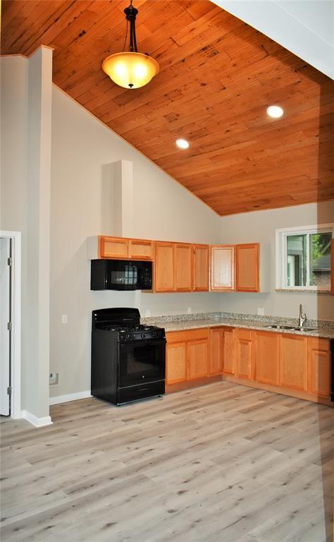 815 Leonard Ave, Richmond, TX 77469 - kitchen featuring black appliances, wood ceiling, high vaulted ceiling, light wood-type flooring, and light brown cabinets