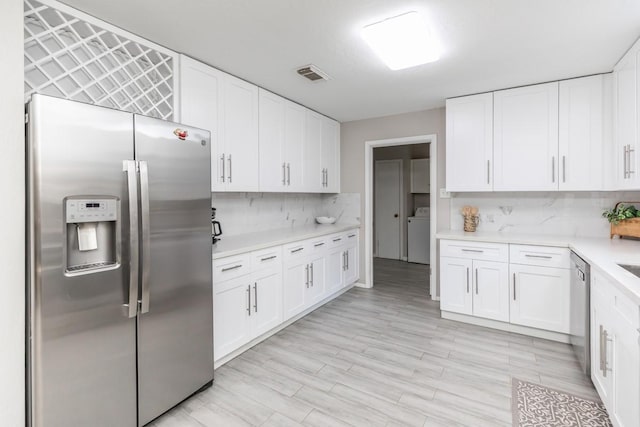 804 Camphor Cir, Village Mills, TX 77663 - kitchen with appliances with stainless steel finishes, backsplash, light countertops, and white cabinetry