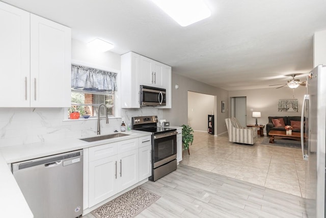 804 Camphor Cir, Village Mills, TX 77663 - kitchen with appliances with stainless steel finishes, open floor plan, tasteful backsplash, light countertops, and white cabinets