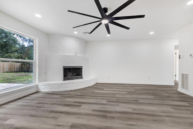 9602 Ballin David Dr, Spring, TX 77379 - unfurnished living room with wood finished floors, ceiling fan, recessed lighting, and a brick fireplace