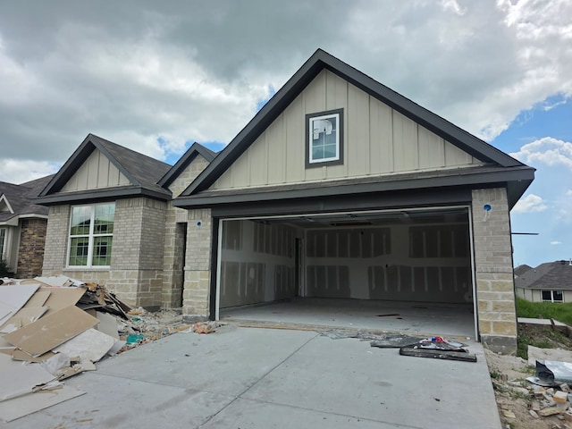 1449 Lake Ridge Dr, Brenham, TX 77833 - view of front of property with board and batten siding, brick siding, driveway, and an attached garage