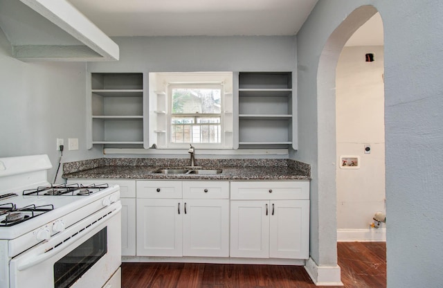 1117 Elliston St, Houston, TX 77023 - kitchen with white range with gas stovetop, open shelves, wall chimney exhaust hood, arched walkways, and dark stone counters