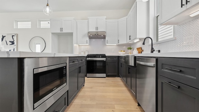 723 Marcella St Unit B, Houston, TX 77091 - kitchen with stainless steel appliances, under cabinet range hood, backsplash, and light wood finished floors