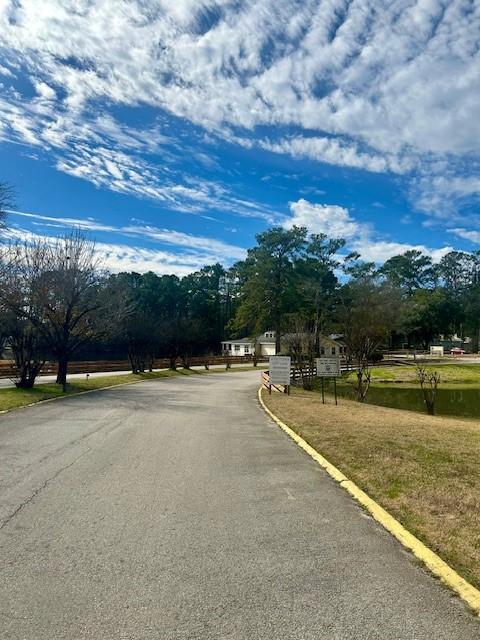 157 Honeysuckle, Livingston, TX 77351 - view of asphalt road featuring curbs