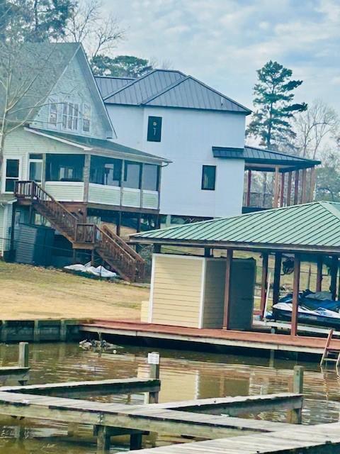 157 Honeysuckle, Livingston, TX 77351 - back of house featuring a standing seam roof, a metal roof, and boat lift