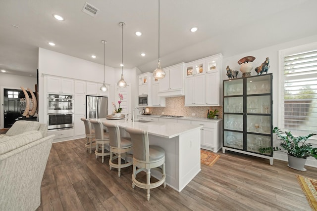 13305 Newcastle Creek Ct, Houston, TX 77059 - kitchen with stainless steel appliances, backsplash, an island with sink, dark wood finished floors, and recessed lighting