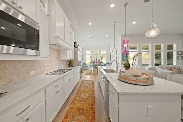 13305 Newcastle Creek Ct, Houston, TX 77059 - kitchen with appliances with stainless steel finishes, open floor plan, light wood-style floors, and recessed lighting