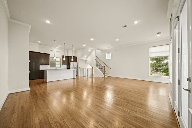 1034 W 26th St Unit D, Houston, TX 77008 - unfurnished living room with ornamental molding, recessed lighting, stairs, and light wood-style flooring