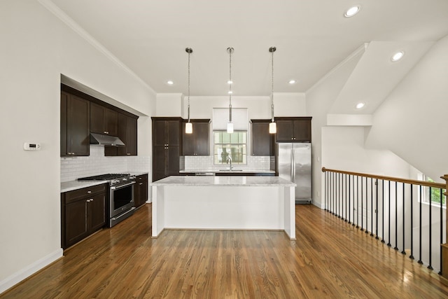 1034 W 26th St Unit D, Houston, TX 77008 - kitchen with appliances with stainless steel finishes, under cabinet range hood, a kitchen island, dark brown cabinets, and ornamental molding