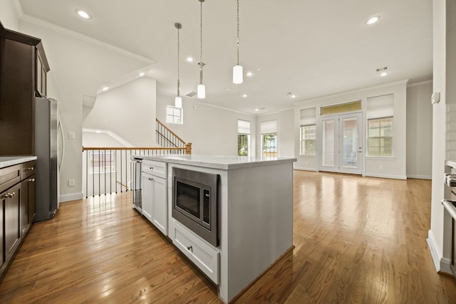 1034 W 26th St Unit D, Houston, TX 77008 - kitchen featuring stainless steel appliances, crown molding, dark brown cabinetry, recessed lighting, and open floor plan