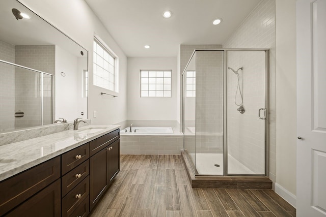 1034 W 26th St Unit D, Houston, TX 77008 - bathroom with vanity, a garden tub, wood finished floors, a stall shower, and recessed lighting