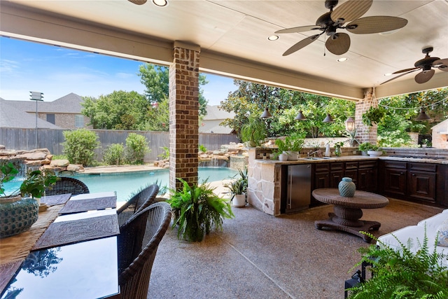 12902 Tamarack Bend Ln, Humble, TX 77346 - fenced backyard featuring an outdoor kitchen, ceiling fan, and a patio