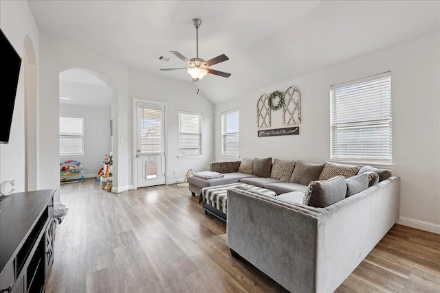9111 Regan Way, Mont Belvieu, TX 77523 - living room featuring ceiling fan, arched walkways, plenty of natural light, wood finished floors, and vaulted ceiling