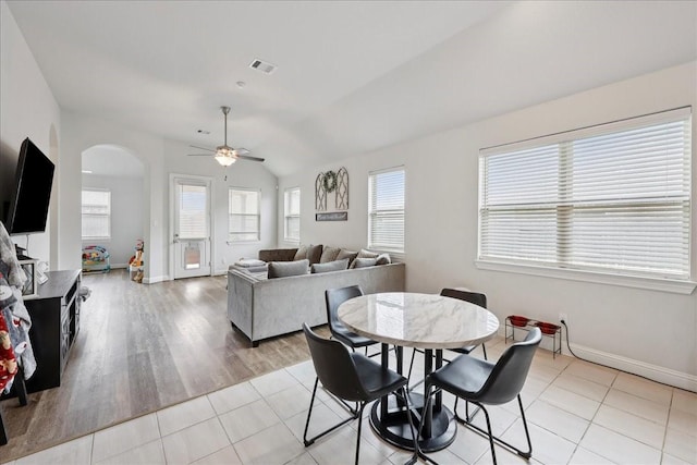 9111 Regan Way, Mont Belvieu, TX 77523 - dining room featuring arched walkways, a ceiling fan, lofted ceiling, and light tile patterned flooring