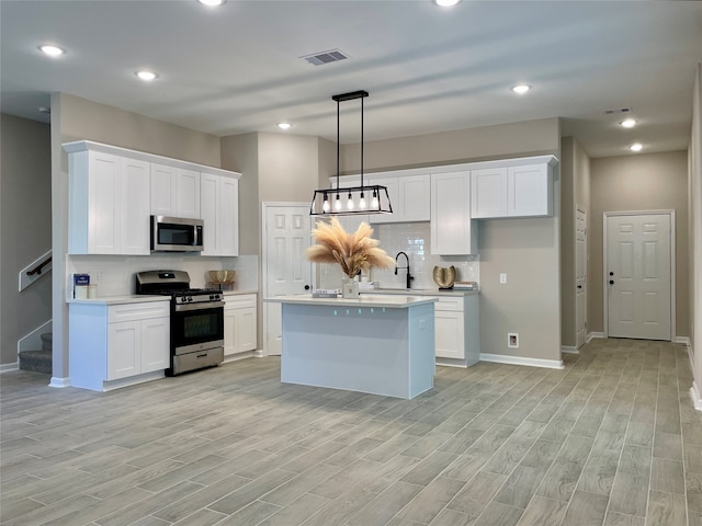 8832 Curry Rd, Houston, TX 77093 - kitchen featuring appliances with stainless steel finishes, light countertops, decorative backsplash, white cabinets, and light wood-style floors