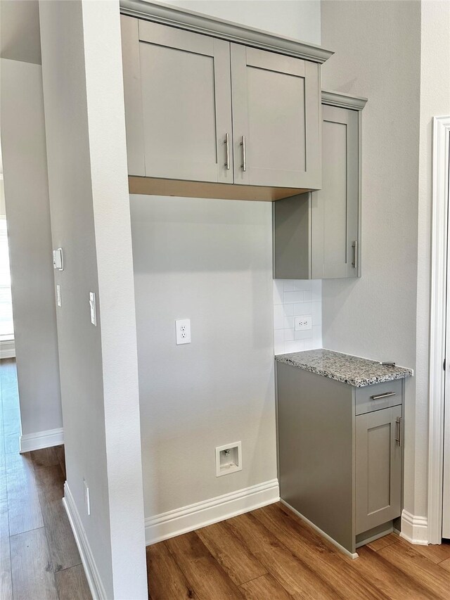 4318 Karam Lndg, Dickinson, TX 77539 - kitchen with gray cabinets, light wood-type flooring, light stone counters, and decorative backsplash