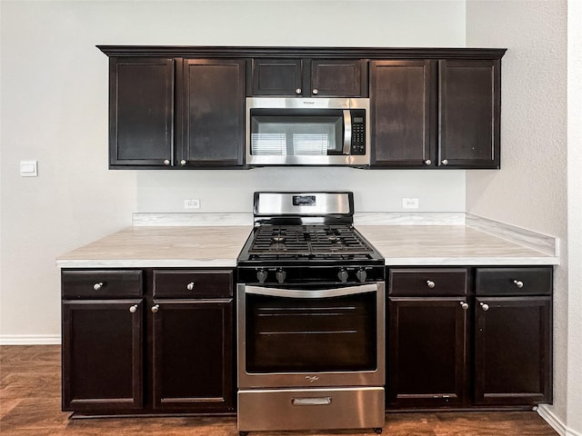 14047 Thunder Pines Dr, Conroe, TX 77302 - kitchen with stainless steel appliances, light countertops, dark wood-style floors, and dark brown cabinets