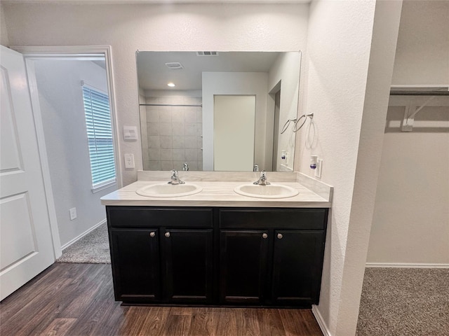 14127 Carly Pines Ct, Conroe, TX 77302 - full bath with double vanity, wood finished floors, a textured wall, and a shower