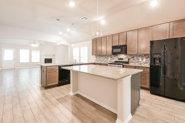 2233 Garden Square Path, Spring, TX 77386 - kitchen with black appliances, a peninsula, a fireplace, lofted ceiling, and decorative backsplash