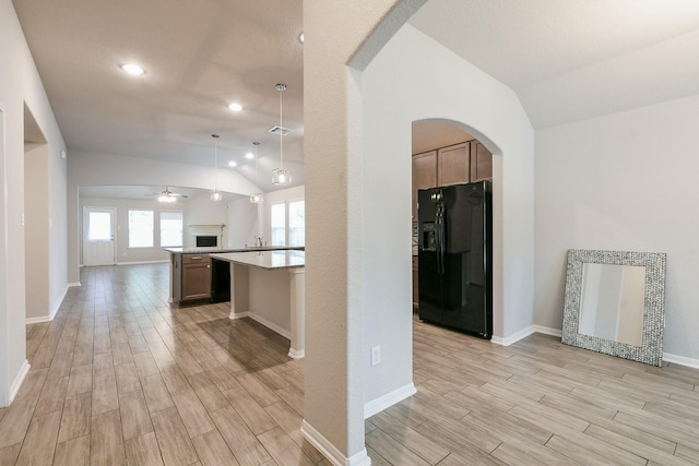 2233 Garden Square Path, Spring, TX 77386 - kitchen featuring black refrigerator with ice dispenser, lofted ceiling, open floor plan, light wood finished floors, and arched walkways