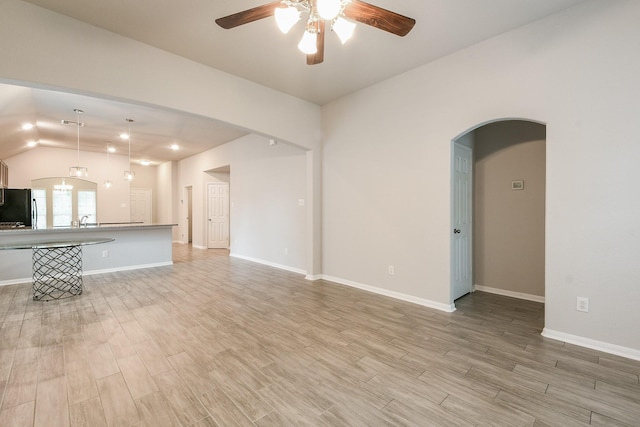 2233 Garden Square Path, Spring, TX 77386 - unfurnished living room featuring ceiling fan, arched walkways, light wood-style floors, and lofted ceiling
