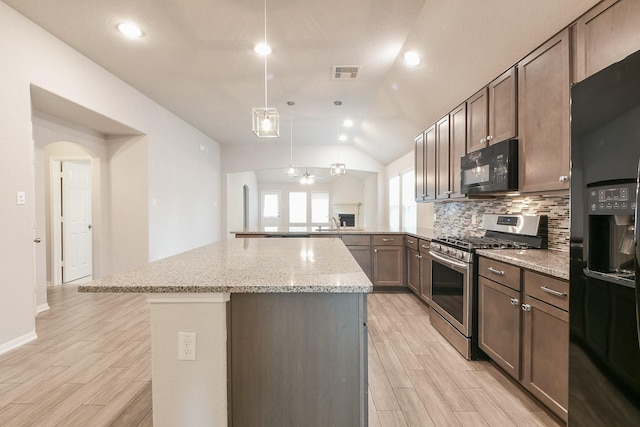 2233 Garden Square Path, Spring, TX 77386 - kitchen with black appliances, decorative backsplash, light wood-style flooring, vaulted ceiling, and a kitchen island
