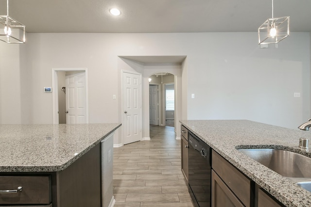 2233 Garden Square Path, Spring, TX 77386 - kitchen with black dishwasher, light wood-style floors, arched walkways, pendant lighting, and light stone countertops