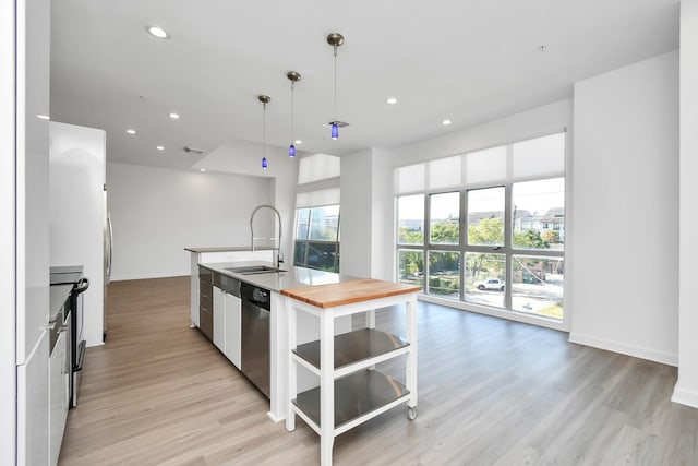 207 Pierce St Unit 301, Houston, TX 77002 - kitchen featuring a center island with sink, wooden counters, light wood-style floors, stainless steel dishwasher, and recessed lighting