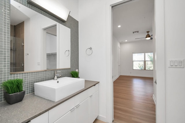 207 Pierce St Unit 301, Houston, TX 77002 - bathroom with wood finished floors, decorative backsplash, vanity, ceiling fan, and recessed lighting