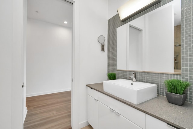 207 Pierce St Unit 301, Houston, TX 77002 - full bathroom with decorative backsplash, vanity, and wood finished floors