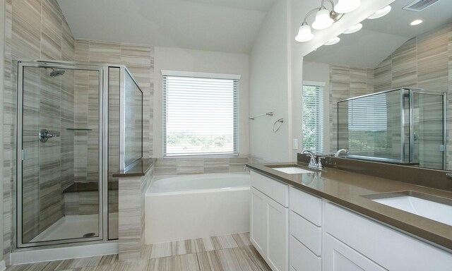 239 Biltmore Loop, Montgomery, TX 77316 - bathroom featuring healthy amount of natural light, double vanity, a shower stall, and vaulted ceiling