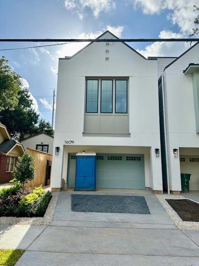 1609 Park St, Houston, TX 77019 - view of front facade with stucco siding, driveway, and an attached garage