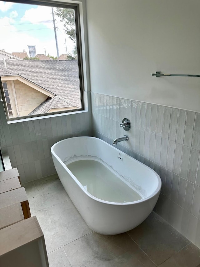 1609 Park St, Houston, TX 77019 - full bathroom with a freestanding tub, a wainscoted wall, tile walls, and tile patterned flooring