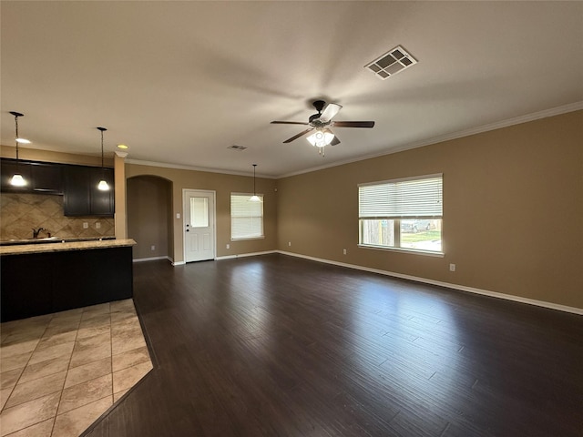 18227 Dusty Terrace Ln, Katy, TX 77449 - unfurnished living room featuring arched walkways, ceiling fan, ornamental molding, and dark wood-style floors