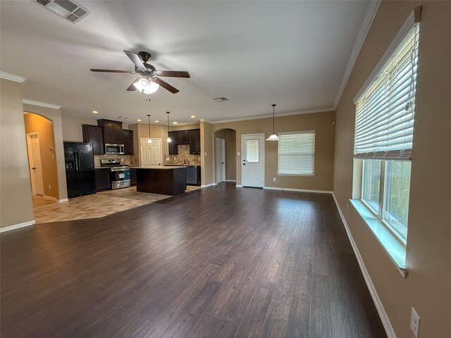 18227 Dusty Terrace Ln, Katy, TX 77449 - unfurnished living room featuring arched walkways, ceiling fan, wood finished floors, and ornamental molding