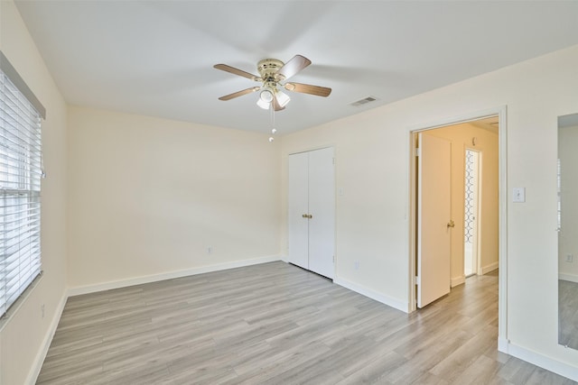 2308 Winrock Blvd Unit 173, Houston, TX 77057 - unfurnished bedroom featuring light wood-style flooring, multiple windows, and ceiling fan