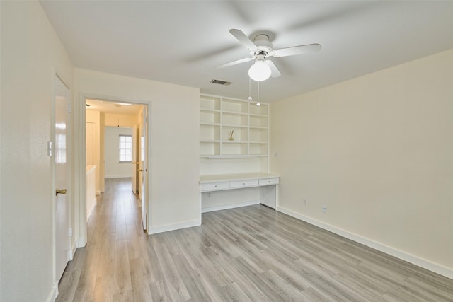 2308 Winrock Blvd Unit 173, Houston, TX 77057 - unfurnished bedroom with built in desk, light wood-style flooring, and ceiling fan