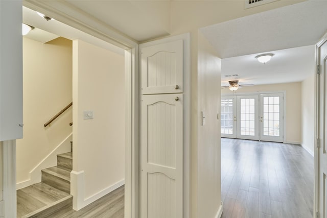 2308 Winrock Blvd Unit 173, Houston, TX 77057 - hallway featuring light wood-style flooring, stairway, and french doors