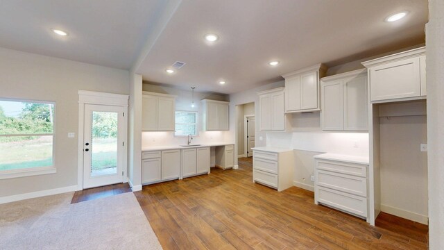 58 Lantana Ct, Lake Jackson, TX 77566 - kitchen with wood finished floors, recessed lighting, white cabinets, and hanging light fixtures