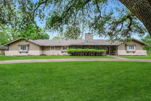 36602 Hondo Rd, Simonton, TX 77485 - ranch-style house with stone siding, a chimney, a front lawn, and board and batten siding