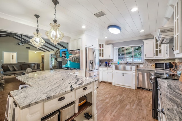 36602 Hondo Rd, Simonton, TX 77485 - kitchen featuring stainless steel appliances, light wood-type flooring, a chandelier, decorative backsplash, and light stone countertops