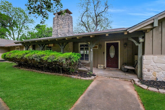 36602 Hondo Rd, Simonton, TX 77485 - entrance to property featuring a chimney, board and batten siding, a lawn, and covered porch