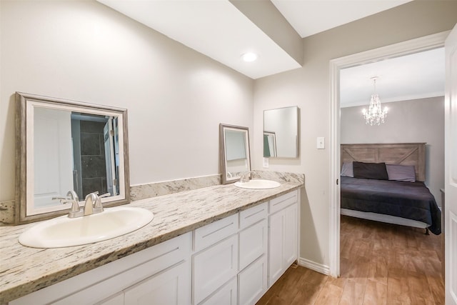 36602 Hondo Rd, Simonton, TX 77485 - bathroom featuring double vanity, wood finished floors, a chandelier, and connected bathroom