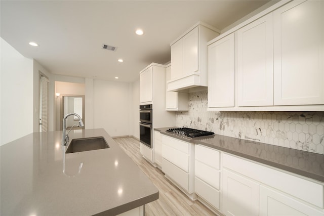 29423 Red Rocks Park Dr, Katy, TX 77494 - kitchen featuring appliances with stainless steel finishes, light wood finished floors, recessed lighting, decorative backsplash, and white cabinetry