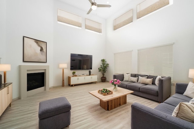 29423 Red Rocks Park Dr, Katy, TX 77494 - living room with ceiling fan, a high ceiling, a fireplace, and light wood-type flooring