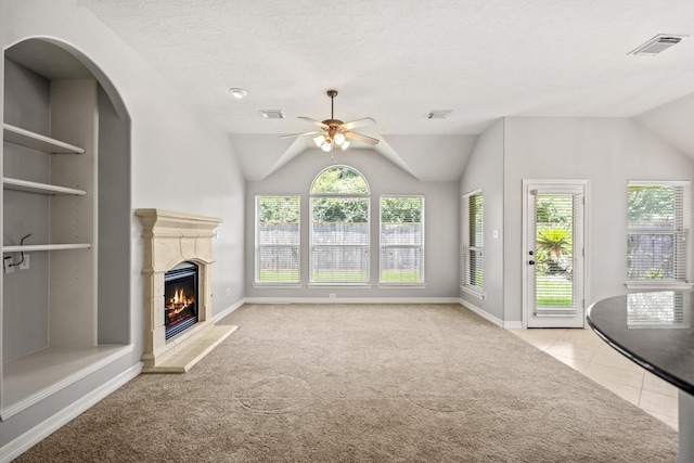 16115 Woodbend Trail Dr, Houston, TX 77070 - unfurnished living room with ceiling fan, carpet floors, a fireplace, lofted ceiling, and tile patterned flooring
