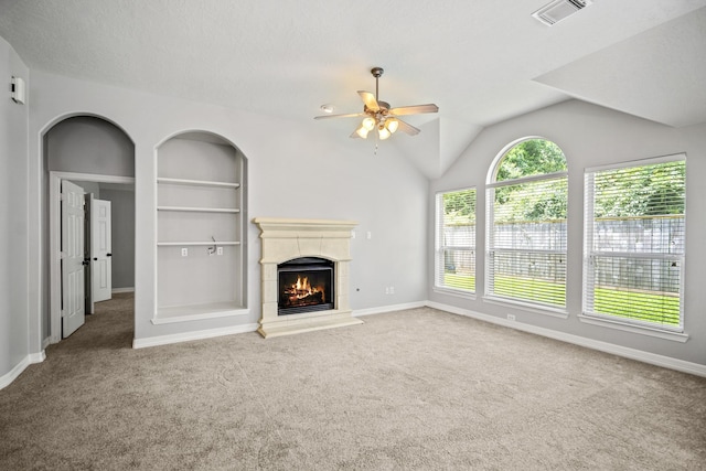 16115 Woodbend Trail Dr, Houston, TX 77070 - unfurnished living room featuring ceiling fan, carpet floors, a warm lit fireplace, built in shelves, and vaulted ceiling