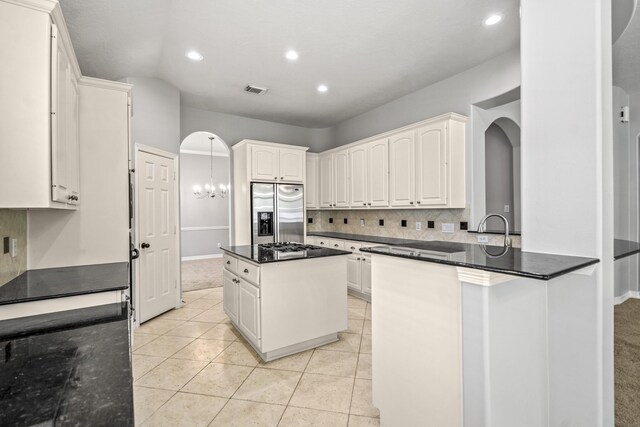 16115 Woodbend Trail Dr, Houston, TX 77070 - kitchen with stainless steel fridge with ice dispenser, a peninsula, decorative backsplash, recessed lighting, and white cabinetry